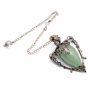 Detailed view of the vintage green stone pendulum with ornate bronze metal frame
