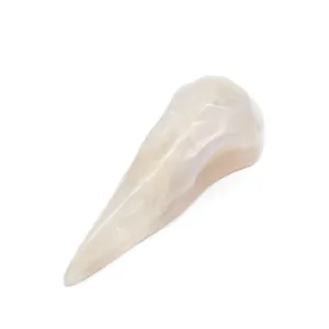 Detailed macro of carved white moonstone crystal bird skull with iridescent surface