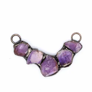 Detailed view of a vintage raw amethyst crystal pendant with rustic metal frame.