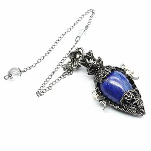 Detail shot of an antique silver crystal pendulum pendant featuring a blue lapis lazuli stone