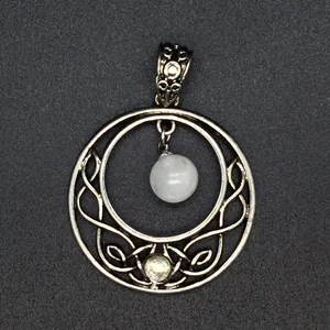 Detailed view of an antique silver circular moon pendant with a suspended white bead.