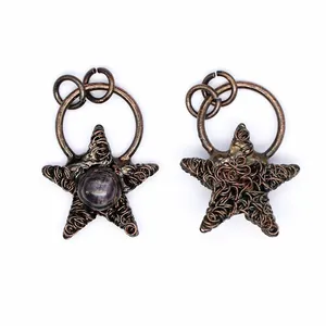 Macro detail showing front and back of vintage star wire wrapped pendants with stone