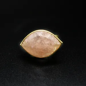 Macro detail showing the faceted strawberry quartz marquise-cut stone on a golden ring band