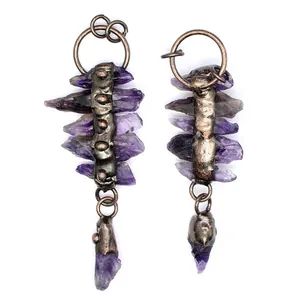 Detailed view of vintage earrings with raw purple amethyst crystals and dark metal spine