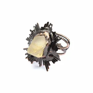 Détail d'une bague vintage en cristal jaune brut avec sertissage en métal effet soleil