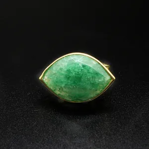 Detailed view of a marquise-cut green crystal ring in eye shape with gold setting