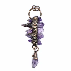 Close-up detail of a vintage raw amethyst crystal pendant with antique bronze metal.