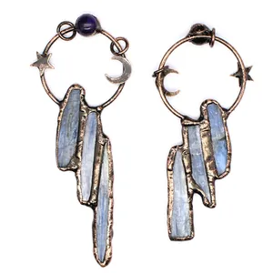 Detailed view of raw blue kyanite pendants with vintage copper moon and star motifs