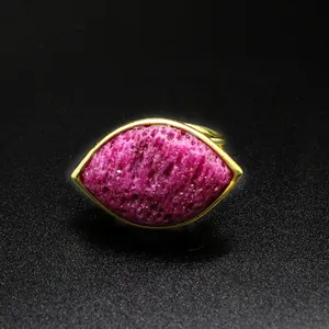 Detailed macro view of textured pink strawberry crystal in a marquise gold ring setting.