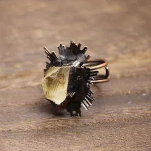 Vue macro détaillée d'une bague vintage en cristal jaune brut avec monture bronze.