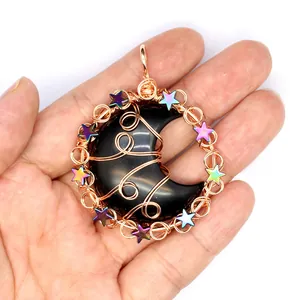 Close-up of handmade wire wrapped black obsidian moon pendant with colorful stars