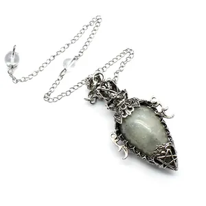 Detail of antique silver crystal pendulum pendant with ornate metal casing and pentagram