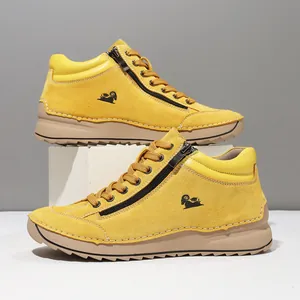 Close-up of yellow suede casual boots with hand-stitched details and side zipper