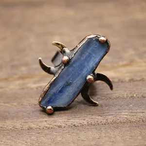 Vue macro détaillée de la pierre bleue brute et de la bague lune en cuivre vintage