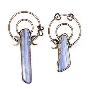 Macro view of vintage style copper frame kyanite raw stone pendants on white background