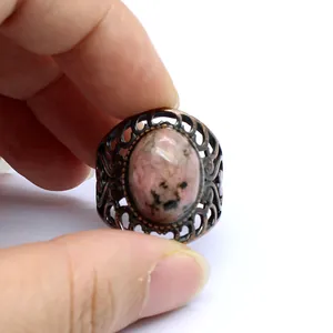 Close-up detail of a vintage medieval style filigree ring with pink natural stone.
