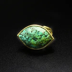 Macro view of a faceted marquise-cut green natural gemstone ring in gold setting