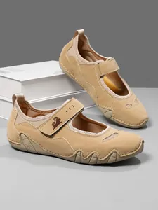 Detailed view of khaki Mary Jane casual shoes with hook and loop strap and goat logo.