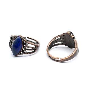 Dettaglio di due anelli vintage regolabili in rame con pietra blu a marquise