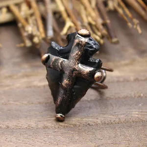 Vue détaillée de la bague pointe de flèche en obsidienne avec cage en croix cuivrée