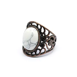 Antique bronze hollowed-out ring featuring an oval white marble stone inlay.