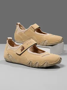 Side view of tan suede Mary Jane sneakers with velcro strap and rugged sole