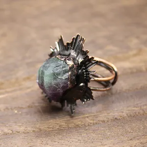 Gros plan d'une bague médiévale vintage avec cristal de fluorite brut et monture soleil