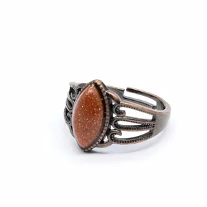 Dettaglio ravvicinato di un anello vintage traforato con intarsio in pietra di sole marrone