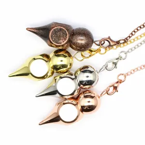 Primer plano de cuatro péndulos de radiestesia en acabados de oro, plata, bronce y rosa.