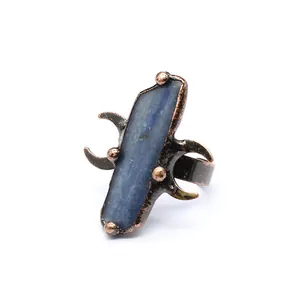 Gros plan d'une bague vintage médiévale avec cristal bleu brut et détails de croissant