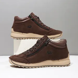 Detailed side view of brown hand-stitched casual ankle boots featuring side zippers and soft soles
