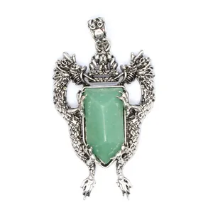 Close-up of vintage silver dragon pendant with a shield-shaped green gemstone insert