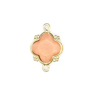 Detailed view of faceted peach moonstone quatrefoil pendant with 18K gold double loops