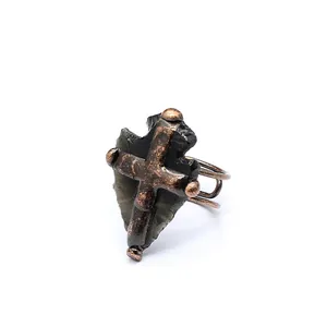 Détail d'une bague médiévale en obsidienne avec une croix en bronze de style rétro