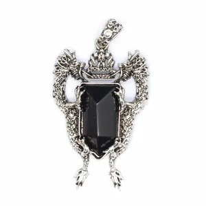Detail view of a vintage silver double dragon shield pendant with black onyx gemstone.