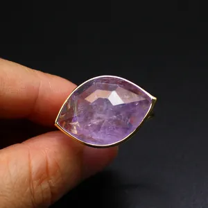 Detailed macro view of large faceted purple amethyst ring in a gold bezel setting