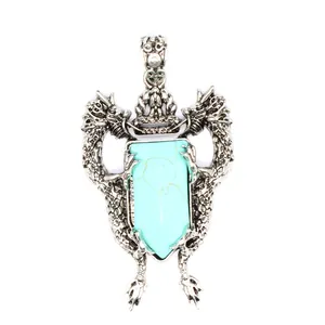 Detailed view of antique silver double dragon shield pendant with turquoise stone inlay
