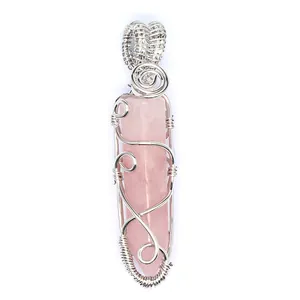 Close-up detail of a handmade silver wire wrapped rose quartz hexagonal crystal pendant