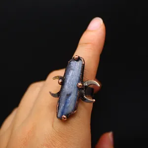 Gros plan d'une bague vintage en cristal brut avec monture médiévale en cuivre lune