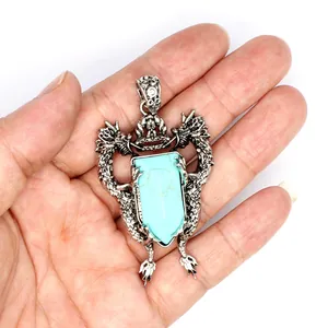 Detailed view of antique style double dragon shield pendant with turquoise stone inlay