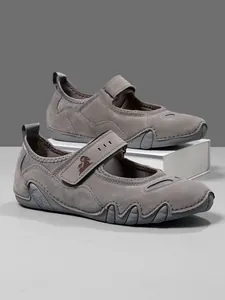 Close-up of grey Mary Jane sneakers with velcro straps and unique wavy sole design