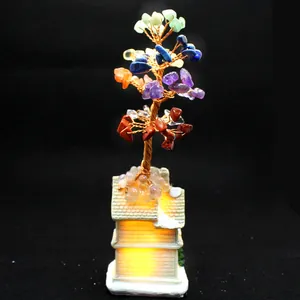 Detail of 7 chakra crystal money tree with hand-woven copper wire on glowing house base
