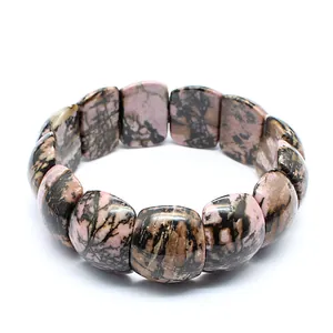 Primo piano di bracciale in pietra naturale Rodonite con motivi rosa e neri.