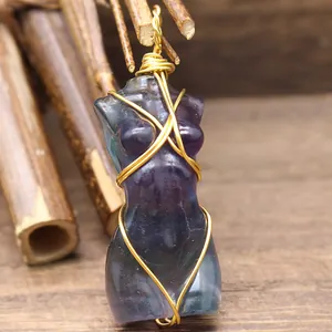 Vista detallada de un colgante de piedra natural con forma de torso femenino hecho a mano