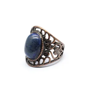 Detailed view of a vintage hollow bronze ring featuring an oval blue natural stone