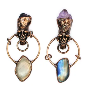Detailed view of two gothic retro skull pendants with amethyst and labradorite stones