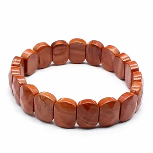 Macro view of polished red jasper faceted stone stretch bracelet with marbled patterns