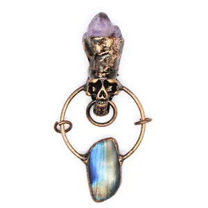 Detail view of a vintage gothic skull pendant with amethyst and labradorite stones.