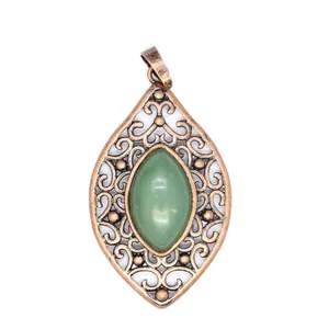 Dettaglio di un ciondolo vintage in bronzo traforato con pietra naturale verde ovale