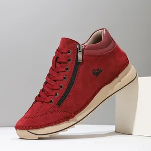 Detailed view of red suede women's casual shoes with side zipper and hand-stitched sole